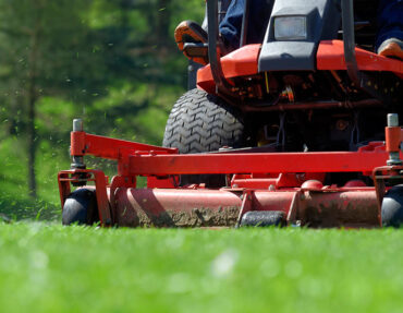 Landscaper mowing commercial lawn.