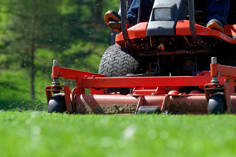 Landscaper mowing commercial lawn.