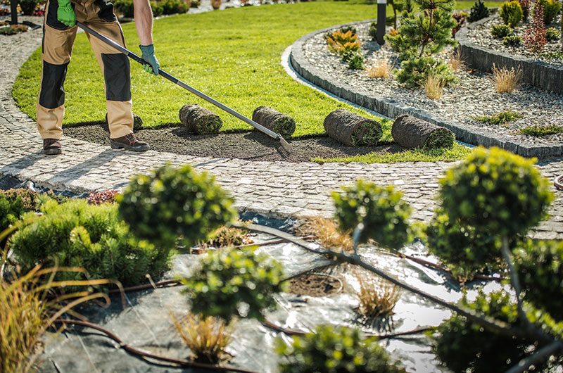 Landscaper raking the ground in preparation of adding grass sod.